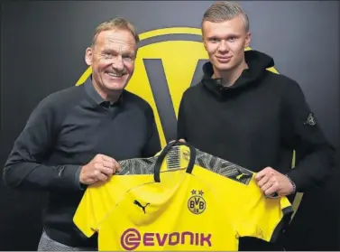  ??  ?? El CEO del Dortmund, Hans-Joachim Watzke, posa con el nuevo fichaje del club, Erling Haaland.