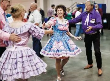  ??  ?? The National Square Dancing Convention has drawn people from all over the country to Oklahoma City. Barb Darcey, of Newton, Kan., dances with Luther Kim, of Corpus Christi, Texas, on Thursday.