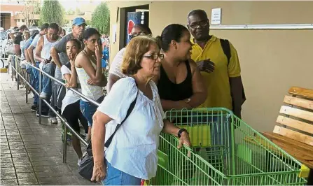  ??  ?? Long queue:
People waiting in line outside a grocery store in San Juan to buy food that wouldn’t spoil and that they could prepare without electricit­y. — AP
