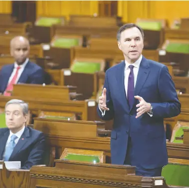  ?? ADRIAN WYLD / THE CANADIAN PRESS ?? With a limited number of MPs on hand and spread out, Finance Minister Bill Morneau responds to a question
after tabling the government’s COVID-19 financial measures bill in the House of Commons on Wednesday.
