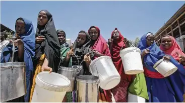  ?? Farah Abdi Warsameh photos / Associated Press ?? Displaced girls who fled the drought in southern Somalia wait in line to receive food at a camp in Mogadishu. Somalia’s prime minister said 110 people have died from hunger in the past 48 hours.