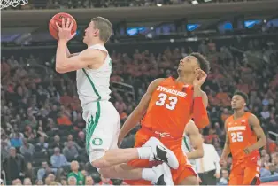  ?? MARY ALTAFFER/ASSOCIATED PRESS ?? Oregon guard Payton Pritchard, left, goes to the basket past Syracuse forward Elijah Hughes on Friday in the 2K Empire Classic in New York. Oregon won, 80-65.