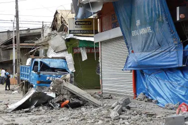  ?? BING GONZALES ?? A MINI dump truck and a motorcycle were pinned from fallen debris in Padada town in Davao del Sur after a magnitude 6.9 earthquake struck areas of Mindanao Sunday afternoon.