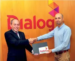  ??  ?? Azwan Khan - Group Chief Operating Officer at Dialog Axiata PLC, exchanging the agreement for the affiliatio­n with Ajai Singh – President, Colombo Fashion Week