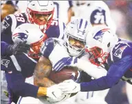  ?? Adam Glanzman / Getty Images ?? The Cowboys’ Ezekiel Elliott (21) is tackled during a game against the Patriots on Sunday at Gillette Stadium in Foxborough, Mass.