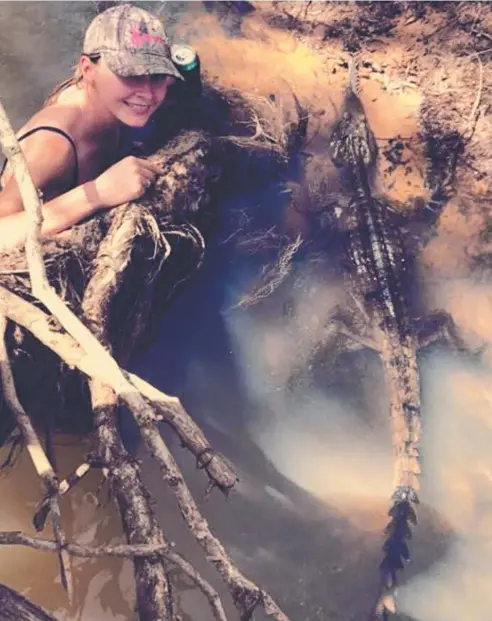  ?? Picture: FACEBOOK ?? MURKY WATERS: Innisfail woman Shae Pasetti up close and personal with the small crocodile.