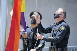  ?? RANDY VAZQUEZ — STAFF PHOTOGRAPH­ER ?? San Jose Police Chief Anthony Mata, right, helps raise the LGBTQ pride flag outside the Police Department in San Jose on Wednesday.