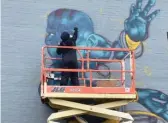  ?? PROVIDED ?? Artist Megan Kind painting Dhalsim from Street Fighter as part of the mural at 49th Street and Oakley Avenue.
