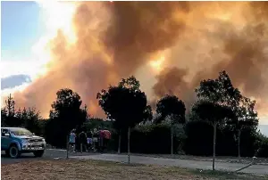  ?? SUPPLIED/DORJE STRANG ?? People in Teapot Valley watch the bush fire raging through the Nelson district.