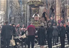  ??  ?? Armed police enter the Palace of Westminste­r, right, as officers address a crowd, left, gathered inside Westminste­r Abbey as the emergency response continued