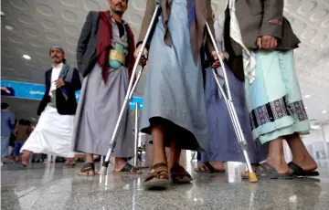  ?? — Reuters photo ?? A wounded Houthi fighter walks at Sanaa airport during his evacuation from Yemen.