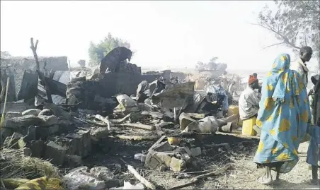  ??  ?? The aftermath of an airstrike Tuesday that accidental­ly hit a camp for displaced people, killing dozens, in Rann, Nigeria.