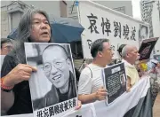  ??  ?? Protesters hold pictures of late Chinese Nobel Peace laureate Liu Xiaobo during a protest outside the Chinese liaison office in Hong Kong yesterday.