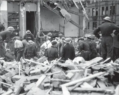  ??  ?? Above: Rescuers survey the wreckage of a house in Scotstoun, bombed during one of four raids in one night in October 1940. Below: workers help to rescue people from their shattered homes in Clydebank