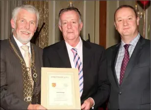  ??  ?? Paco Sheehan receives a scroll on behalf of his late father Paco, who was the team trainer, from Mayor Jim Moore and Killian Duignan, Sarsfields chairman.