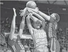  ?? Jerry Larson / Associated Press ?? Baylor’s Nina Davis, center, gets caught in close quarters with West Virginia defenders Teana Muldrow, left, and Lanay Montgomery in the second half.