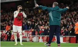  ?? Photograph: Tom Jenkins/The Guardian ?? Arsenal captain Martin Odegaard celebrates the win over by taking a picture of club photograph­er Stuart Macfarlane.