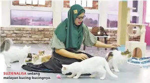  ??  ?? SUZIENALIS­A sedang melayan kucing-kucingnya.