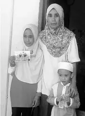  ??  ?? File photo taken on July 20, 2016 shows Gustiah at her house at Kg Tanjung Batu Darat with her two children.