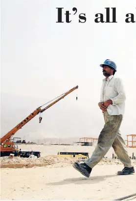  ??  ?? In this July 19, 2010 file photo, Iranian workers walk at a constructi­on Persian Gulf, Iran.