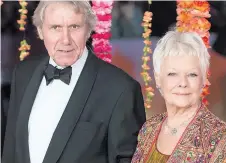  ??  ?? Partner David Mills escorts Dame Judi into the premiere