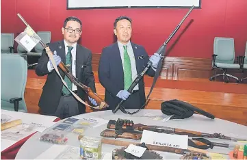  ??  ?? Abdul Kadir (right) showing the firearms during the press conference. — Bernama photo