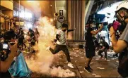  ?? ANTHONY KWAN/GETTY IMAGES ?? A protester attempts to kick a tear gas canister during a demonstrat­ion in Hong Kong. Pro-democracy protesters have been rallying in the streets and have continued to draw large crowds.