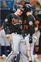  ?? ?? The Orioles’ Ramón Urías, right, celebrates with Austin Hays after hitting a two-run home run during the eighth inning Friday, his second homer of the game.