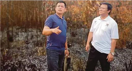 ?? [Foto Jabatan Bomba Dan Penyelamat /BH] ?? Ling Hii (kiri) memberi penerangan mengenai kebakaran hutan Elektrik Luar Bandar, Datuk Dr Abdul Rahman Junaidi. di Matang kepada Menteri Muda Bekalan