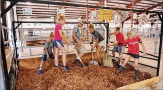 ?? MARSHALL GORBY / STAFF ?? 4-H kids work to prepare the barns Thursday for the upcoming Greene County Fair. The fairground­s are in Xenia.