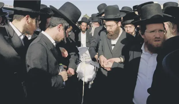  ??  ?? Ultra-orthodox Jewish mourners carry the body of a victim of Jewish pilgrim stampede during a funeral ceremony in Jerusalem