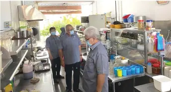  ??  ?? Yii (second right) and councillor­s check the kitchen of a food outlet.