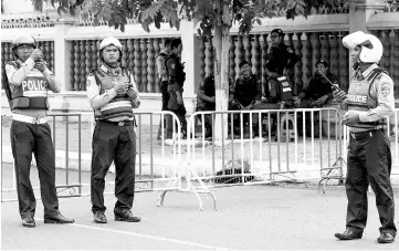  ?? — AFP photo ?? Cambodian police stand guard as they block a street near the Supreme Court during a hearing over the extended pre-trial detention of Kem Sokha, in Phnom Penh.