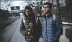  ?? JAKE MAY/THE FLINT JOURNAL VIA AP ?? MICHIGAN STATE INTERNATIO­NAL STUDENTS DHEERAJ
THOTA (LEFT) and Chirag Bhansari, both freshman studying computer science, found a single rose on their walk to class as campus opens back up for the first day of classes on Monday at Michigan State University in East Lansing, Mich.