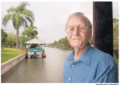  ?? STAFF FILE PHOTO ?? Patrick Smith, author of “A Land Remembered,” is pictured in 2003 in front of the canal behind his home on Merritt Island. Smith died in 2014 at age 86.