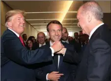  ?? The Associated Press ?? U.S. President Donald Trump, left, shakes hands with Turkey’s President Recep Tayyip Erdogan as French President Emmanuel Macron looks on at NATO headquarte­rs in Brussels on Wednesday.