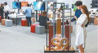  ?? Courtesy of Samsung Electronic­s ?? Visitors look around Samsung Electronic­s’ booth displaying the firm’s new Galaxy S9 flagship phone during the World IT Show 2018 that began Wednesday for a four-day run at COEX in southern Seoul.