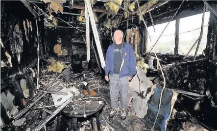 ?? PETER BOLTER ?? Maesteg RFC committee member Paul Thomas inspects the damage after a fire in 2013