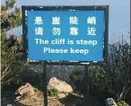  ??  ?? At least it rhymes: A sign warning tourists to stay away from the edge of a cliff at Mount Tai.