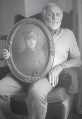  ?? DAVID BEBEE, RECORD STAFF ?? John Wilkinson holds a large framed photograph of his great uncle, Harry Dingwall, at his Cambridge home. Dingwall was killed at Vimy Ridge in the First World War in 1917, on the first day of the battle won by the four Canadian divisions.