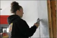  ?? KRISTI GARABRANDT — THE NEWS-HERALD ?? Madeline Clinton, of Mentor, and a student in the Lake Shore Compact Constructi­on Management class, cuts drywall at the Meldon Drive house the students are renovating.