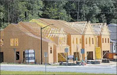  ?? AP/ JOHN BAZEMORE ?? The frames for new town homes are completed in this May 16 photo from Woodstock, Ga. A home price index released Tuesday based on sales in 20 U. S. cities said prices increased 5.6 percent in May.