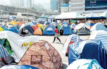  ??  ?? A woman walks past tents set up by pro-democracy protesters in the Occupy Camp in the Admiralty area of Hong Kong. — AFP photo