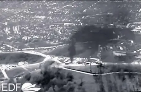  ?? Environmen­tal Defense Fund and Ear t hworks ?? A STILL FROM a video shot on an infrared camera shows a plume of methane caused by the gas leak at the Aliso Canyon facility. The leak began in October, and SoCal Gas has been working to reduce the escaping fumes by easing pressure in the undergroun­d...