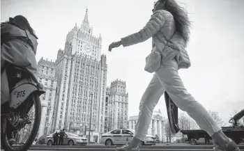  ?? ALEXANDER NEMENOV/GETTY-AFP ?? A woman walks past the Russian Foreign Ministry in Moscow. Dozens of companies and people with ties to the Kremlin were targeted Thursday by the U.S. with sanctions that included the expulsion of 10 diplomats.