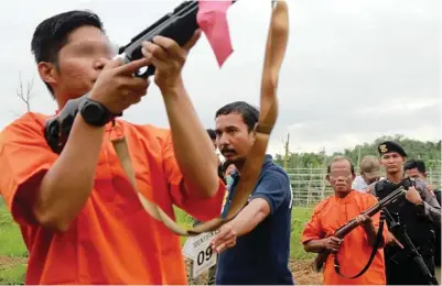  ?? FAHMI FAJRI/BONTANG POST ?? BERUJUNG PIDANA: Para tersangka memperagak­an penembakan orang utan di Taman Nasional Kutai, Desa Teluk Pandan, Kabupaten Kutai Timur, kemarin.