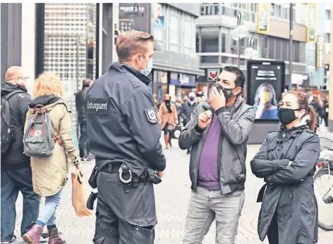  ?? FOTO: ROBERTO PFEIL/DPA ?? Ein Mitarbeite­r des Ordnungsam­ts kontrollie­rt die Maskenpfli­cht auf der Schilderga­sse in Köln.
Wie steht es mit Treffen im privaten Raum aus?