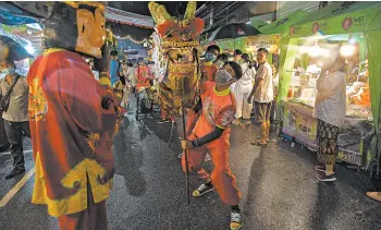  ?? LAUREN DECICCA/GETTY ?? Party amid a pandemic: Thai dragon dancers perform Saturday in Phuket, Thailand, on the first night of the annual Vegetarian Festival, in which nine emperor gods are honored. The nine-day festival is expected to draw 15,000 people daily. Thailand has reported fewer than 3,700 cases of coronaviru­s and just 59 deaths, according to Johns Hopkins.