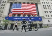  ?? AP PHOTO/FRANK FRANKLIN II ?? Pedestrian­s wearing protective masks during the coronaviru­s pandemic pass by the New York Stock Exchange in New York on July 7.