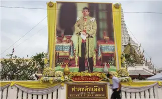  ??  ?? HÄRSKAREN. Stora bilder på den nye kungen Maha Vajiralong­korn är uppsatta över hela Thailand.